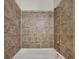 The bathroom has a white tub with brown tiles at 749 Rolling Downs Dr, Loganville, GA 30052