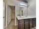 Bright bathroom featuring dual sinks, a large mirror, and a walk-in closet at 749 Rolling Downs Dr, Loganville, GA 30052