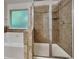 Well-lit bathroom with a glass-enclosed shower and tub at 749 Rolling Downs Dr, Loganville, GA 30052