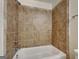 Clean bathroom featuring a white tub and shower with neutral toned tiled walls at 749 Rolling Downs Dr, Loganville, GA 30052