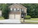 Traditional two-story brick home with a two-car garage and well-manicured front yard at 749 Rolling Downs Dr, Loganville, GA 30052