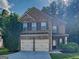 Charming two-story brick home with a two-car garage and a well-manicured lawn at 749 Rolling Downs Dr, Loganville, GA 30052