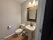 Powder room with pedestal sink, decorative mirror, wood flooring, and a neutral color scheme at 800 Attaway Rd, Bowdon, GA 30108