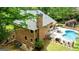 Aerial view of brick home with an in-ground pool, mature trees, and landscaped grounds at 255 Emerald Lake Dr, Fayetteville, GA 30215