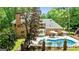 Backyard of brick home featuring a refreshing pool, landscaped garden beds, and mature trees at 255 Emerald Lake Dr, Fayetteville, GA 30215