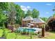 Expansive backyard view of pool, patio and mature trees behind beautiful brick home at 255 Emerald Lake Dr, Fayetteville, GA 30215