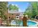 Beautiful brick home showcasing backyard pool, iron fence, and manicured garden beds at 255 Emerald Lake Dr, Fayetteville, GA 30215