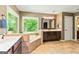Bathroom featuring a tub under a window, double vanity and beige tile flooring at 255 Emerald Lake Dr, Fayetteville, GA 30215
