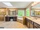 Bright bathroom with double vanity, jacuzzi tub under a skylight, and a large window at 255 Emerald Lake Dr, Fayetteville, GA 30215