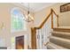 Grand entryway featuring a beautiful staircase, chandelier, and large arched window for natural light at 255 Emerald Lake Dr, Fayetteville, GA 30215