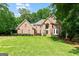 Beautiful brick two-story home with a well-manicured lawn and mature trees at 255 Emerald Lake Dr, Fayetteville, GA 30215