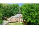 Charming brick home with a landscaped lawn and mature trees on a sunny day at 255 Emerald Lake Dr, Fayetteville, GA 30215