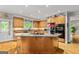 Well-lit kitchen featuring wooden cabinets and an island with granite countertops and a gas stovetop at 255 Emerald Lake Dr, Fayetteville, GA 30215