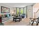 Cozy living room featuring a leather sofa, bay windows, and plush seating at 255 Emerald Lake Dr, Fayetteville, GA 30215