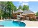 Backyard pool area featuring a large in-ground pool, brick home, and green landscaping at 255 Emerald Lake Dr, Fayetteville, GA 30215