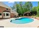 In-ground backyard pool with a brick house, lounge chairs, and lush green landscaping at 255 Emerald Lake Dr, Fayetteville, GA 30215