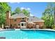 Backyard pool area featuring a large in-ground pool, brick home, and landscaping at 255 Emerald Lake Dr, Fayetteville, GA 30215