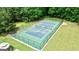 Aerial view of fenced-in tennis court with a manicured lawn at 255 Emerald Lake Dr, Fayetteville, GA 30215
