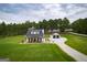 Beautiful farmhouse-style home with lush green lawn and tree-lined backdrop at 211 Hogan Coweta Rd, Hogansville, GA 30230