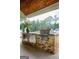 Covered outdoor kitchen featuring brickwork, a stainless steel grill, and a view of the backyard at 211 Hogan Coweta Rd, Hogansville, GA 30230