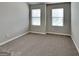An empty bedroom offers a clean, neutral carpet and natural light from two windows at 1392 Worcester Trl, Mcdonough, GA 30253