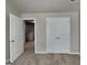 A bedroom with carpeted floors and an open doorway to a staircase with double door closet at 1392 Worcester Trl, Mcdonough, GA 30253