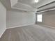 Bright main bedroom featuring tray ceiling, neutral walls, and carpet flooring at 1392 Worcester Trl, Mcdonough, GA 30253
