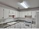Bright kitchen featuring white cabinets, marbled countertops, and white appliances at 10 Nicole Ct, Covington, GA 30016