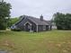 View of the rear of the house, featuring a large backyard and wooded area at 10 Nicole Ct, Covington, GA 30016