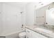 A stylish bathroom with a white tiled shower, granite counter, and modern fixtures at 1590 Sw Cherry Hill Ln, Conyers, GA 30094
