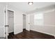 Neutral bedroom featuring wood floors, a closet, white trim and a large window with natural light at 1590 Sw Cherry Hill Ln, Conyers, GA 30094