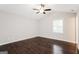 Bright bedroom with hardwood floors, neutral paint, a ceiling fan, and a large window at 1590 Sw Cherry Hill Ln, Conyers, GA 30094