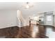 Open-concept living room and kitchen with hardwood floors, white cabinets, and stainless steel appliances at 1590 Sw Cherry Hill Ln, Conyers, GA 30094