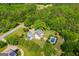 Aerial view showcasing the home, pool, and lush landscaping, surrounded by dense trees at 1745 Stripling Chapel Rd, Carrollton, GA 30116
