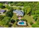 An aerial view of the residence featuring a swimming pool and lush landscaping surrounded by mature trees at 1745 Stripling Chapel Rd, Carrollton, GA 30116