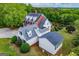 An aerial view shows the residence with a mix of red brick and light siding and a large backyard surrounded by lush trees at 1745 Stripling Chapel Rd, Carrollton, GA 30116