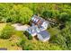 A high-angle aerial shot showcasing the home, expansive lawn, and swimming pool, all surrounded by dense trees at 1745 Stripling Chapel Rd, Carrollton, GA 30116