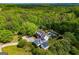 Aerial view of a large home with a swimming pool nestled among lush trees and landscaping at 1745 Stripling Chapel Rd, Carrollton, GA 30116