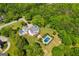 An aerial view of the home with a pool and manicured lawn surrounded by mature trees in a park-like setting at 1745 Stripling Chapel Rd, Carrollton, GA 30116