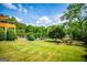 Expansive backyard featuring a swimming pool, lush landscaping, mature trees, and a fire pit area, perfect for outdoor enjoyment at 1745 Stripling Chapel Rd, Carrollton, GA 30116