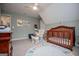 Cozy Bedroom with a wooden crib, rocking chair and a fun alphabet rug creating a warm and inviting space for a baby at 1745 Stripling Chapel Rd, Carrollton, GA 30116