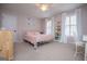 Charming bedroom with pink walls, a white metal frame bed, natural light, and a cozy reading nook at 1745 Stripling Chapel Rd, Carrollton, GA 30116