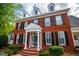 Close up of the red brick facade and covered entryway featuring white columns and dark shutters and a red brick walkway at 1745 Stripling Chapel Rd, Carrollton, GA 30116