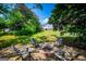 Cozy fire pit area with Adirondack chairs, perfect for outdoor gatherings and relaxation in the landscaped backyard at 1745 Stripling Chapel Rd, Carrollton, GA 30116