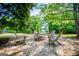 Inviting outdoor fire pit area with Adirondack chairs set amidst a landscaped backyard and lush greenery at 1745 Stripling Chapel Rd, Carrollton, GA 30116