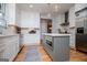 Well-lit kitchen with an island, stainless steel appliances, white cabinets, and hardwood floors at 1745 Stripling Chapel Rd, Carrollton, GA 30116