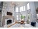 Bright living room features a stone fireplace, modern light fixture, and large windows with outdoor views at 1745 Stripling Chapel Rd, Carrollton, GA 30116
