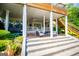 Covered patio with seating and steps leading down to landscaped yard at 1745 Stripling Chapel Rd, Carrollton, GA 30116