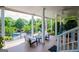 Covered patio seating area with view of pool, trimmed bushes and trees in backyard at 1745 Stripling Chapel Rd, Carrollton, GA 30116