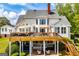 Expansive home exterior showcasing a wooden deck, outdoor seating, manicured landscaping, and a gabled roof at 1745 Stripling Chapel Rd, Carrollton, GA 30116